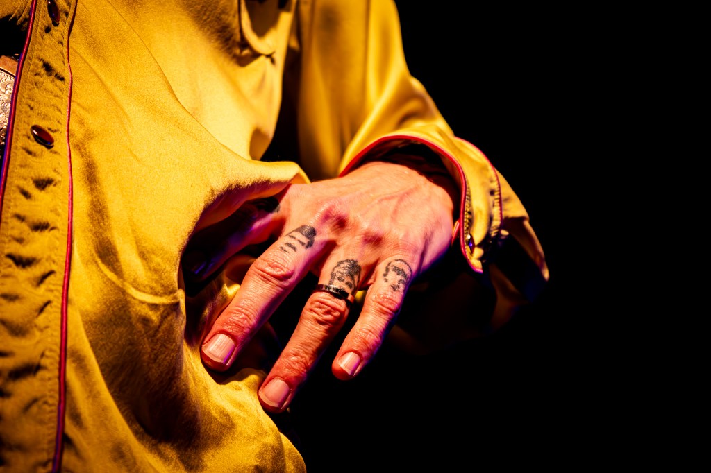 Close-up on Justin Hawkins' hand with tattooed fingers