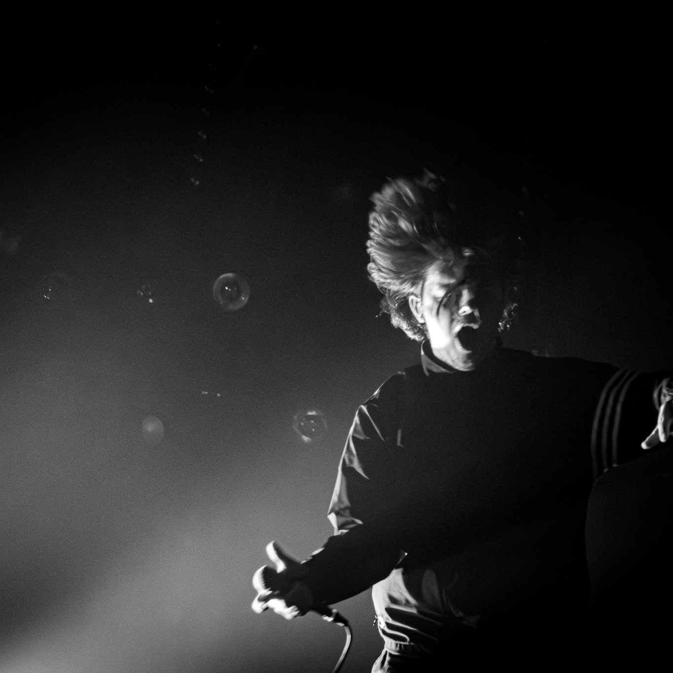 Chalk band's frontman jumping with hair in the air
