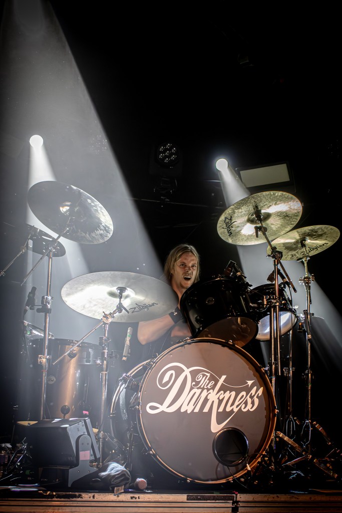 The Darkness' drummer playing on stage