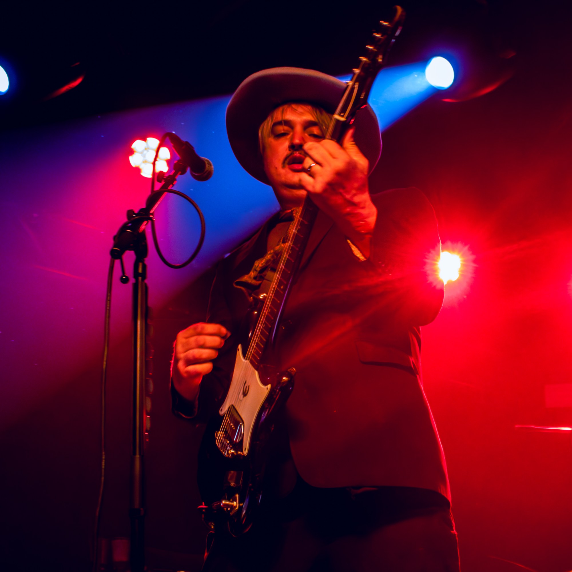 Pete Doherty playing guitar on stage
