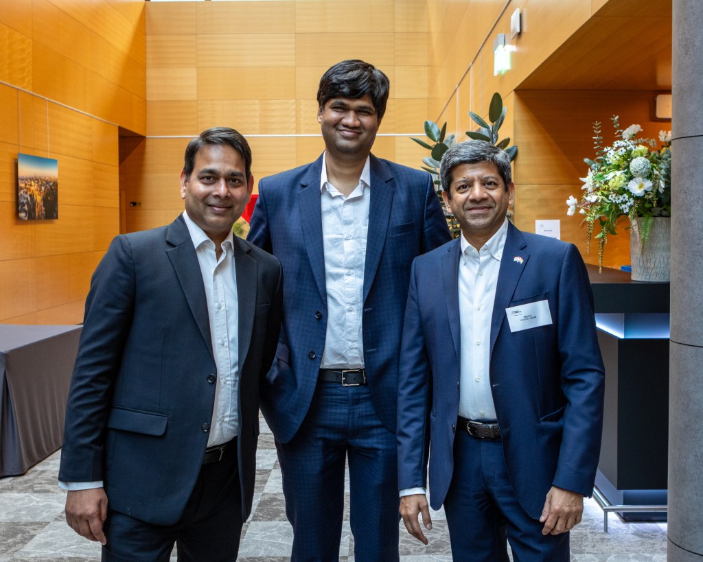 Three businessmen from India posing together during an event